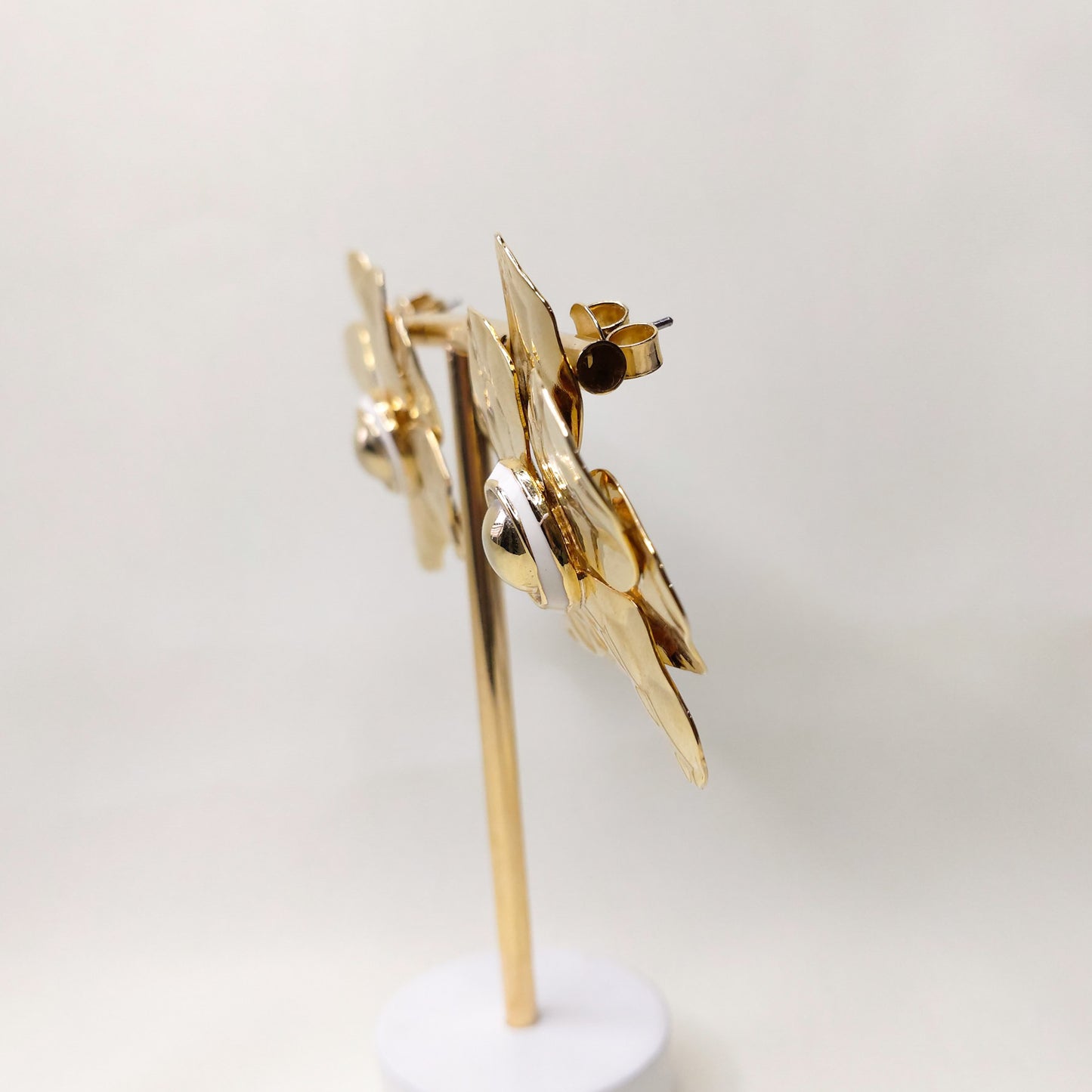 Brinco flor dourado com detalhe branco