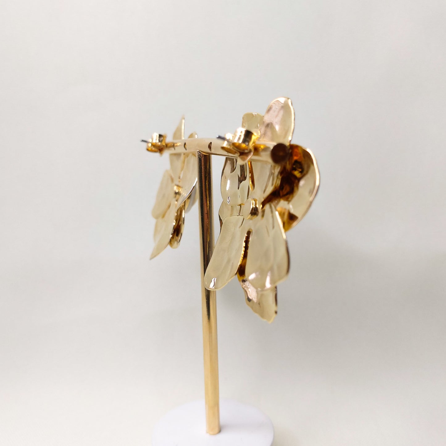 Brinco flor dourado com detalhe branco