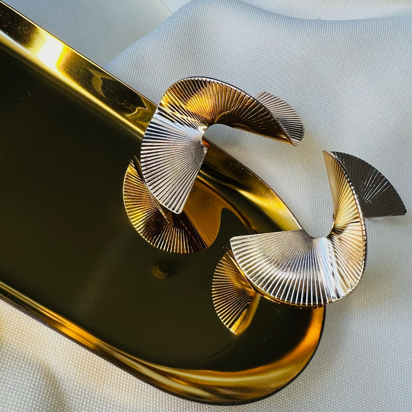 Brinco dourado torcido com textura franzido