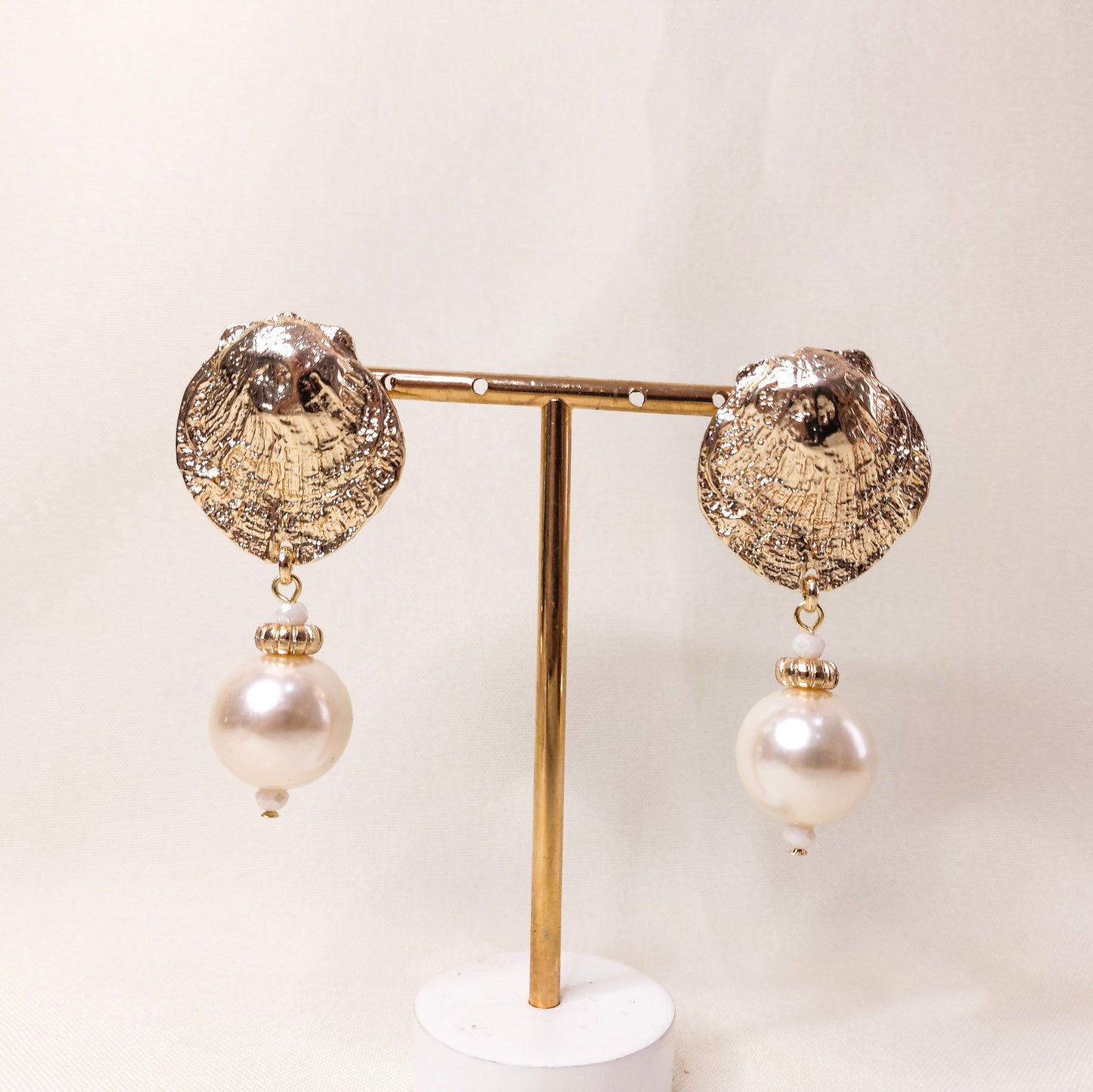 Brinco com textura dourado concha com pingente tipo pérola