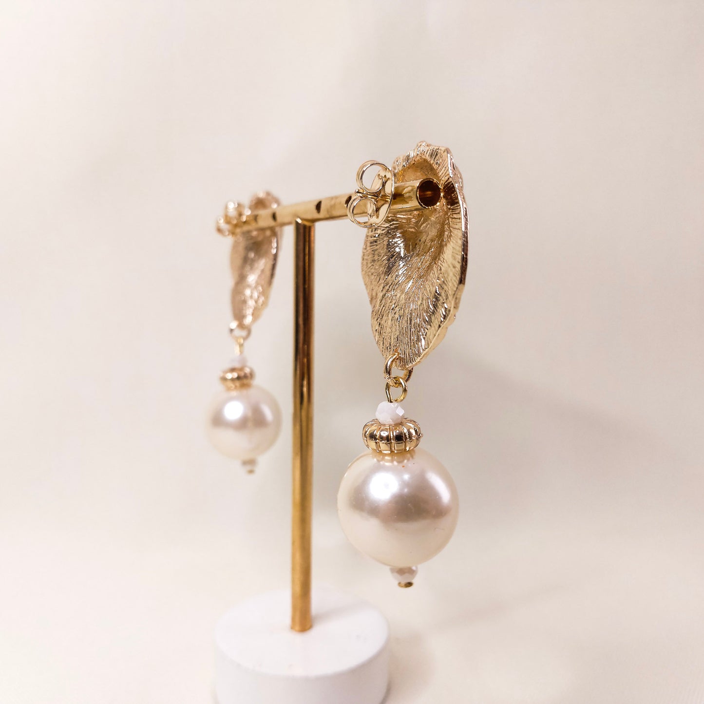 Brinco com textura dourado concha com pingente tipo pérola